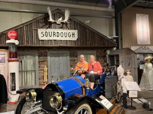 People in museum sitting in an old car