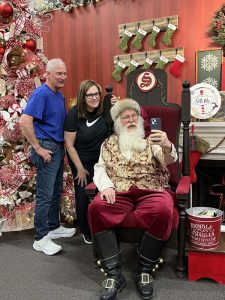 People taking a selfie with Santa Claus