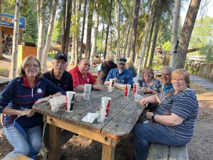 People sitting on picnic table in wooded area