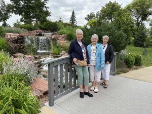 Women standing by garden waterfall